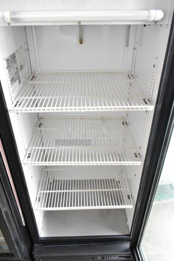 True GDM-12 metal commercial cooler with single glass door, poly-coated racks, 115 volts, 1 phase; interior label visible.