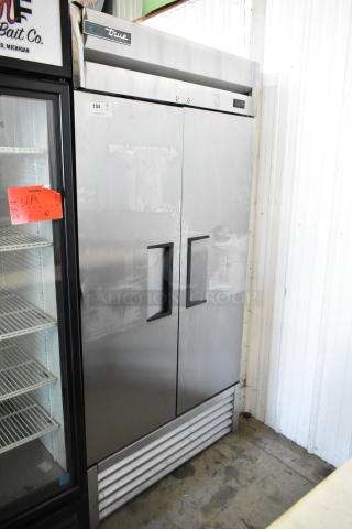 True stainless steel commercial 2-door reach-in cooler with poly-coated racks. Features 115 volts, 1 phase. Good condition.