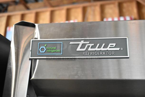 True stainless steel commercial 2-door cooler with poly-coated racks, 115 volts, 1 phase; features "natural refrigerant" label.