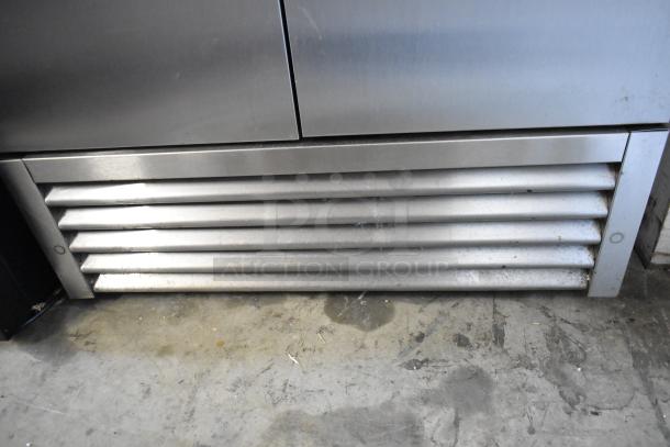 True Stainless Steel Commercial 2 Door Reach In Cooler, visible vent area, used condition, 115V, poly-coated racks.