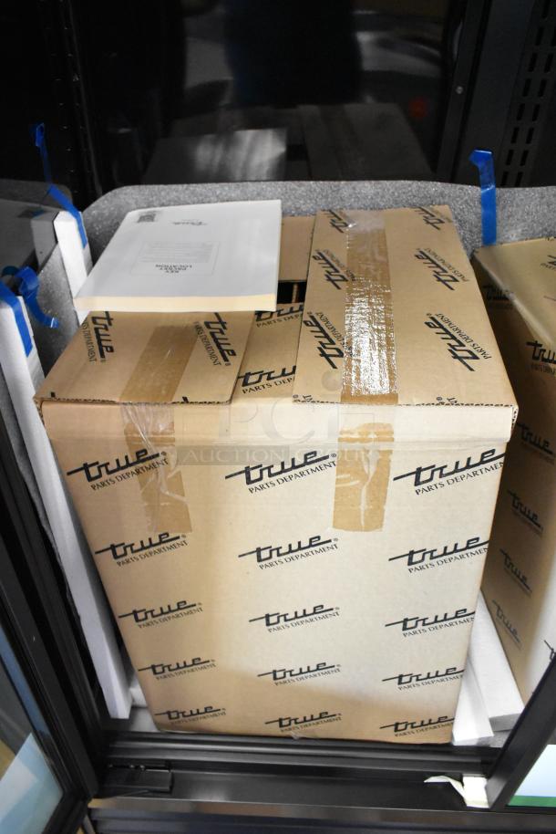 True TVM-48SL-HC 2-door cooler, metal shelves, new in box, 115V, 1 phase, commercial-grade packaging visible.