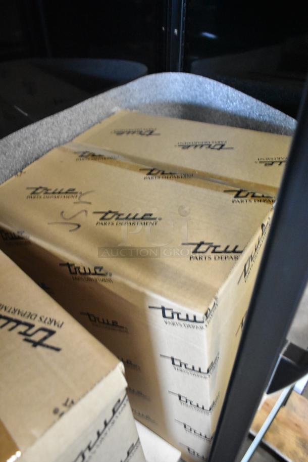 Two True Parts Department boxes inside a commercial cooler. Shelving visible. Model: TVM-48SL-HC. 115V, 1 Phase.
