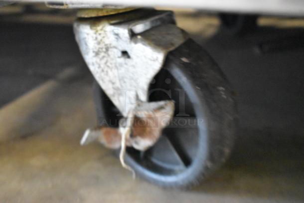 Close-up of a worn caster wheel on the Atosa MSF8308GR stainless steel prep table, indicating signs of wear.
