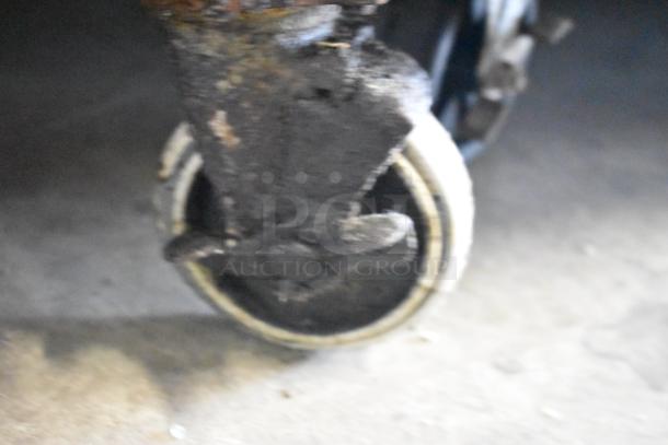 Rusty commercial caster on a Hudson stainless steel prep table, showing wear. 115 volts, 1 phase.