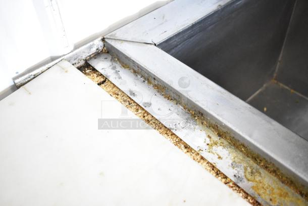 Hudson Stainless Steel Prep Table showing corner with visible food debris and corrosion, used condition.