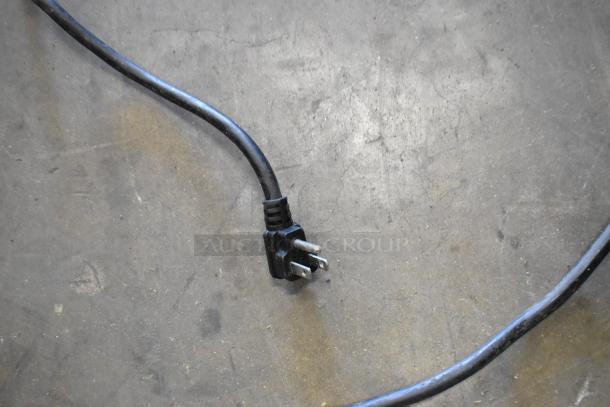Black electrical plug on a concrete floor, likely part of the Atosa MSF8308GR prep table setup.