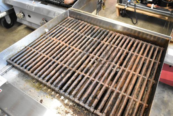 Qualite QLEC-24/NG stainless steel charbroiler grill, natural gas, 60,000 BTU, used, with visible wear on grates.