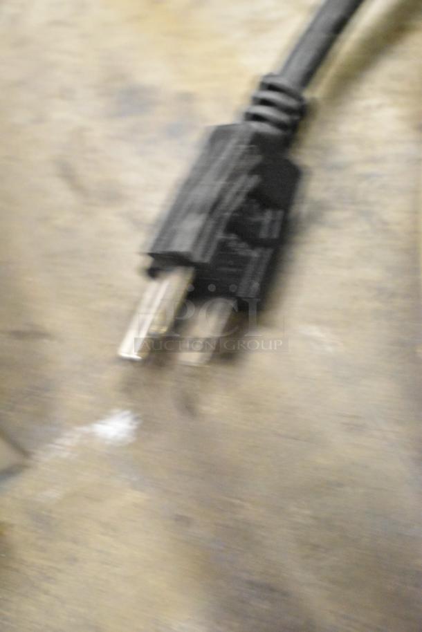 Blurry image of a black electrical power cord with a two-prong plug, possibly related to Avantco 177CO14 oven.