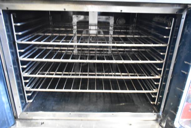 Vulcan VC6GD-SEFCAM convection oven interior with metal racks, view through doors, on commercial casters, stainless steel.
