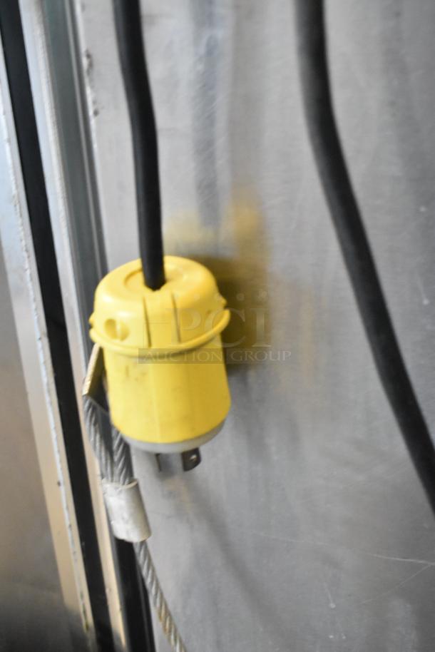 Yellow electrical plug on stainless steel Vulcan convection oven, showcasing utility compatibility.