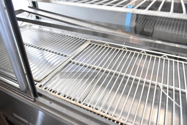 Stainless steel commercial deli display case merchandiser, floor style, 115 volts, 1 phase, shelving visible, used condition.