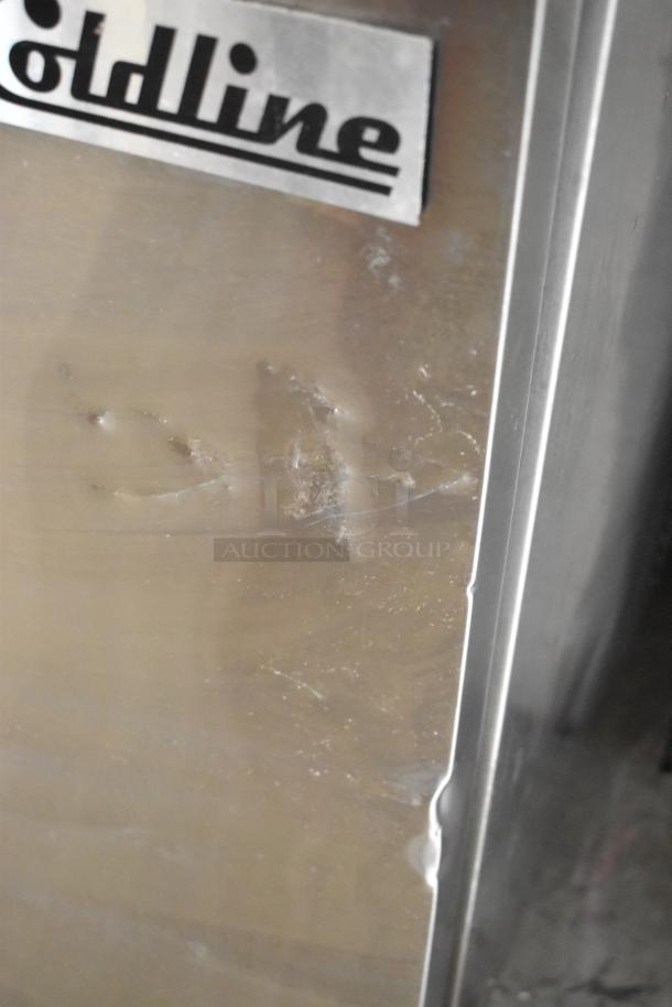 Coldline SP-27 stainless steel commercial prep table with visible surface scratches and dents. Coldline logo on unit.