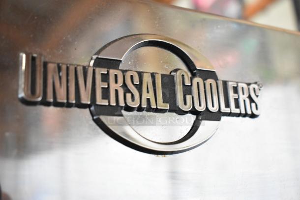 Universal Coolers logo on metal surface. Part of a commercial 2-door reach-in cooler merchandiser, 115 volts, 1 phase.