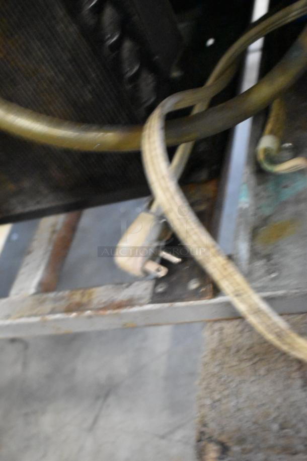 Universal Coolers 2-door reach-in cooler power cord and part of the frame, showing wear and signs of rust. 115V, 1-phase.