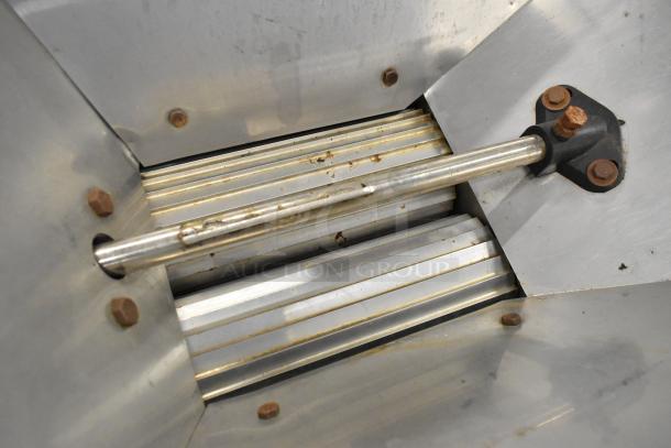 Metal commercial countertop cookie dough depositor, featuring stainless steel construction and signs of wear.