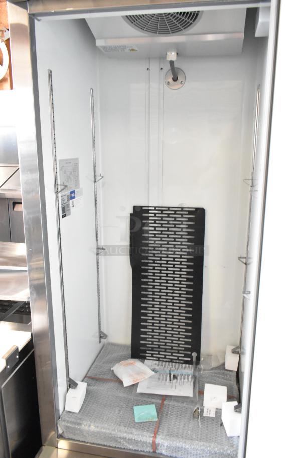Brand new 2024 Avantco 178A19FHC stainless steel commercial freezer, single door, 115V, minor scratches, interior view.