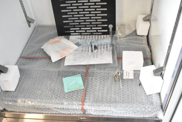 Avantco 178A19FHC stainless steel commercial freezer, new with scratches, 2024 model. Includes bubble wrap, labels, and instructions.