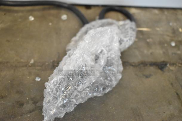 Bubble wrap covering a power cord on a gray concrete floor.