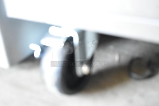 Blurred image of a caster wheel on a Delfield GBSR1P-S commercial cooler, indicating mobility feature.
