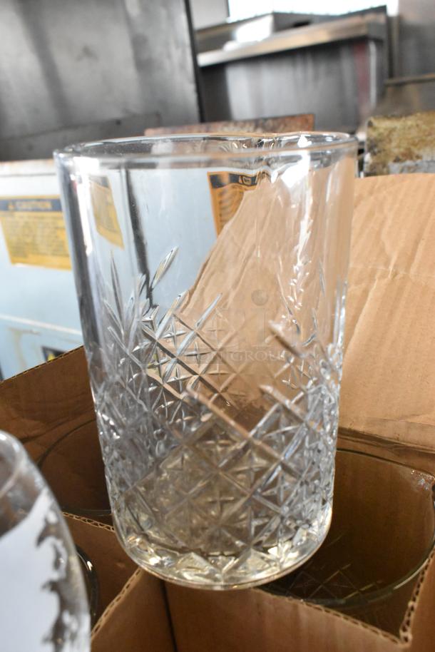 Box containing assorted clear glasses with intricate etched designs, in good condition, no visible markings.