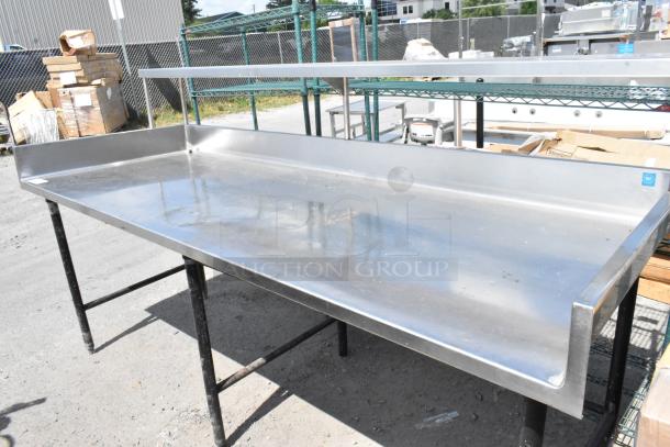 Stainless steel table with back splash and over shelf in good condition, ideal for kitchen or industrial use.
