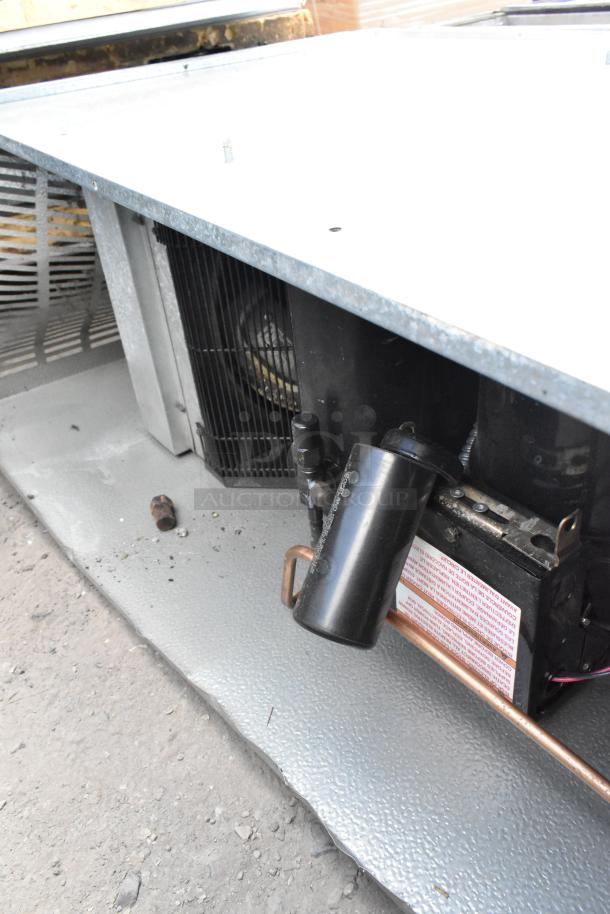 Norlake self-contained walk-in cooler box with compressor and condenser, showing cooling unit components, in used condition.