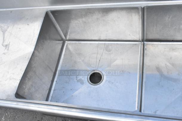 Yukon stainless steel 3 bay sink with dual drain boards, no legs, visible wear, ideal for commercial use.