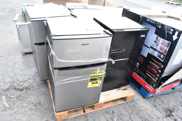Four mini coolers including Galanz GLR31TS1E02 shown on a pallet. Visible Energy Guide on one unit, wrapped for shipment.