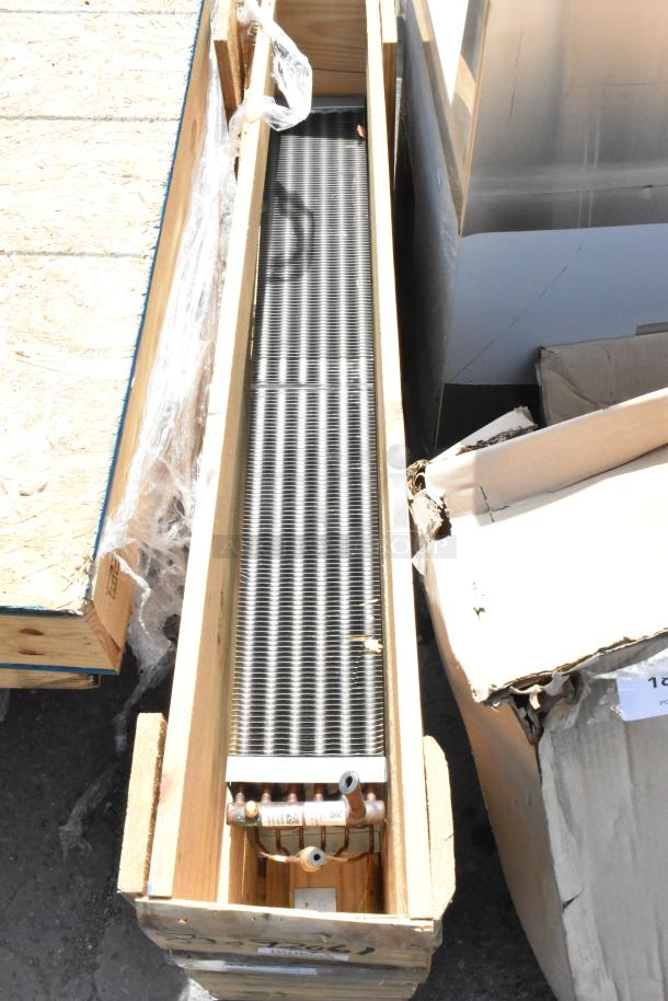Brand new evaporator coil in wooden crate, showing metal fins and copper pipes. Ideal for HVAC system installations.