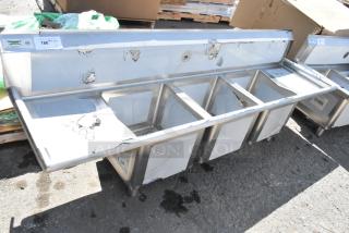 BRAND NEW Regency 600S31515215 stainless steel 3-bay sink with dual drain boards, minor scratches and dents visible.
