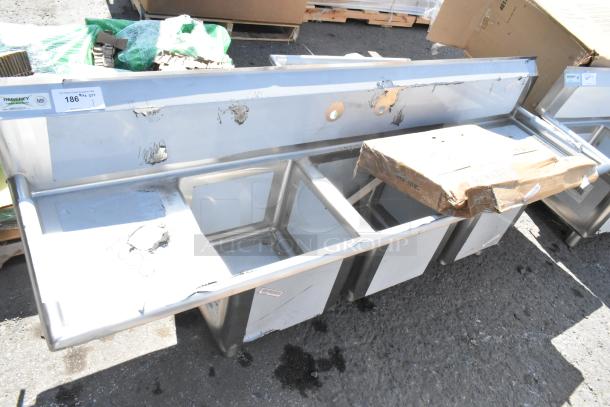 BRAND NEW Regency 600S31515215 stainless steel 3 bay sink with dual drain boards; visible dents and scratches.