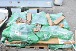 10 brand new scratch and dent items, including table leg base pieces, wrapped in green bubble wrap on a pallet.