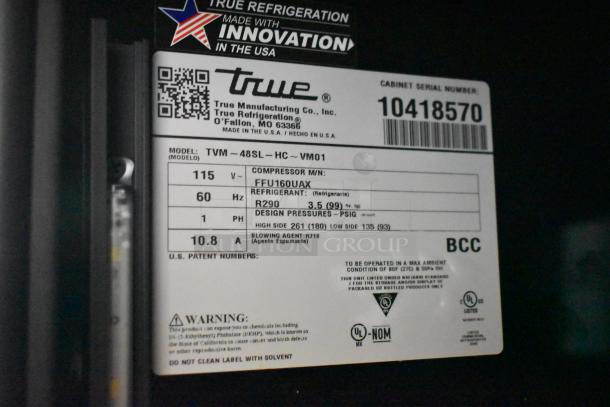 Label on a True TVM-48SL-HC cooler merchandiser detailing model, voltage, refrigerant type, and compliance information.