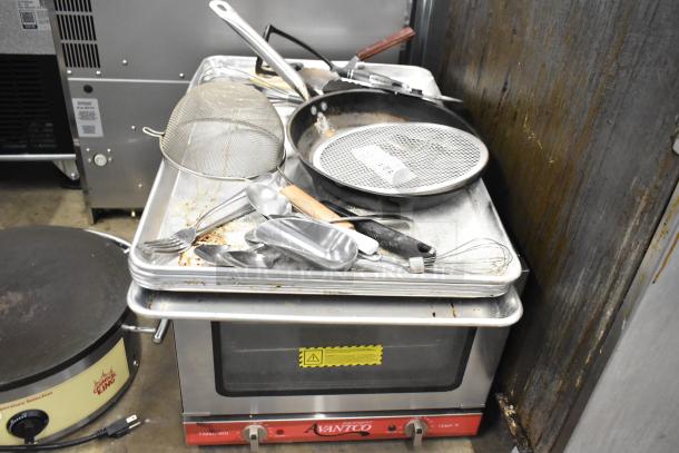 Lot of various kitchen items including a skillet, utensils, mesh strainer, and an Avantco warming unit. Used condition.