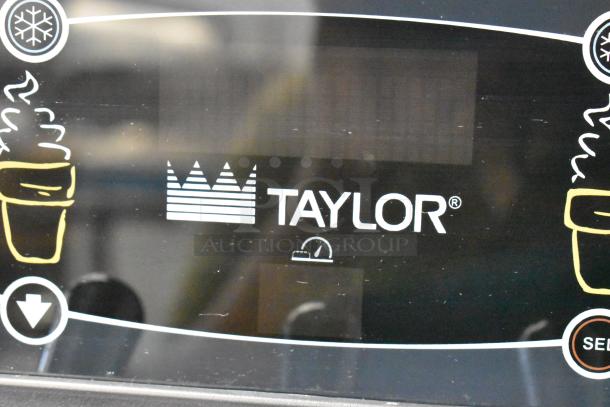 Taylor C723-33 stainless steel commercial soft serve ice cream machine display panel with logo and control icons.