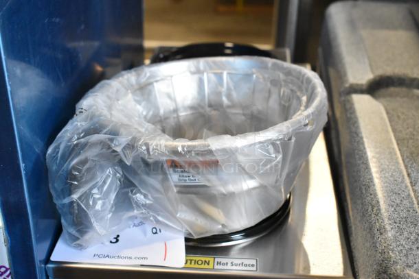 Curtis ALP3GT63A000 stainless steel coffee brewer, brand new, with a plastic wrap, showing hot surface caution label.