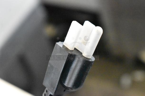 Close-up of a plug from the Avantco VB203 Stainless Steel Commercial Countertop Vertical Broiler, natural gas powered.