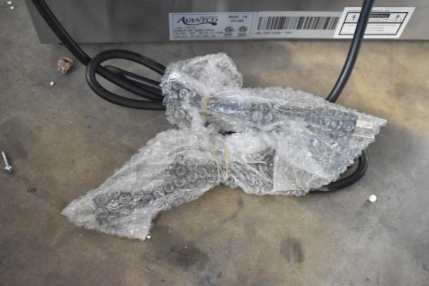 Brand new Avantco 177F102 20 lb. dual tank electric countertop fryer, scratched and dented, with cords, bubble wrap, and visible label.