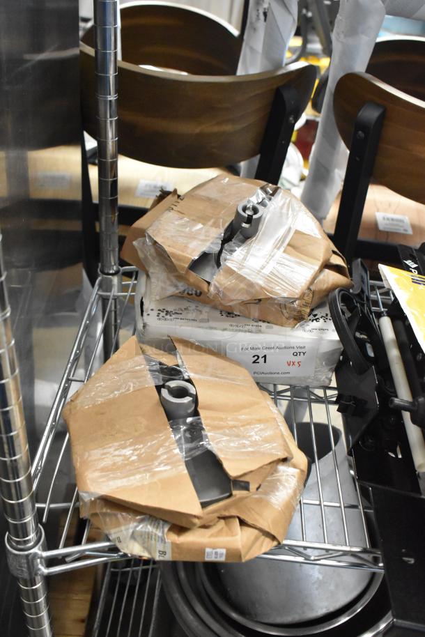 Five brand new scratch and dent Robot Coupe parts, including dicing kits and slicing discs, wrapped in packaging on a metal shelf.