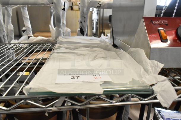 Two brand new glass panes on a shelf, labeled "2 times your bid." Light scratches visible on surface.
