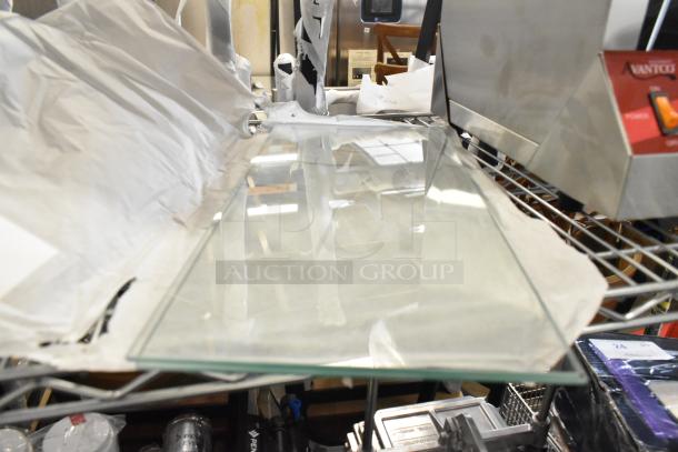 Brand new scratch and dent glass panes on metal rack, ready for auction. Includes two glass panes per bid.