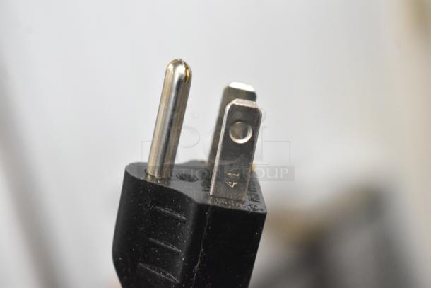 Close-up of a power plug for the Robot Coupe R2 food processor, showing a three-prong design.
