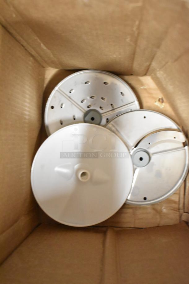 Box with three food processor blades for the Robot Coupe R2, showing various cutting designs for versatility.