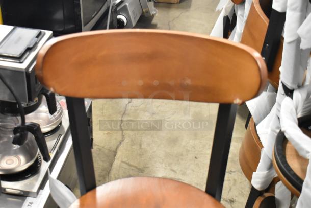 Black metal dining chair with wooden backrest and seat by Lancaster Table & Seating, new with minor scratches.