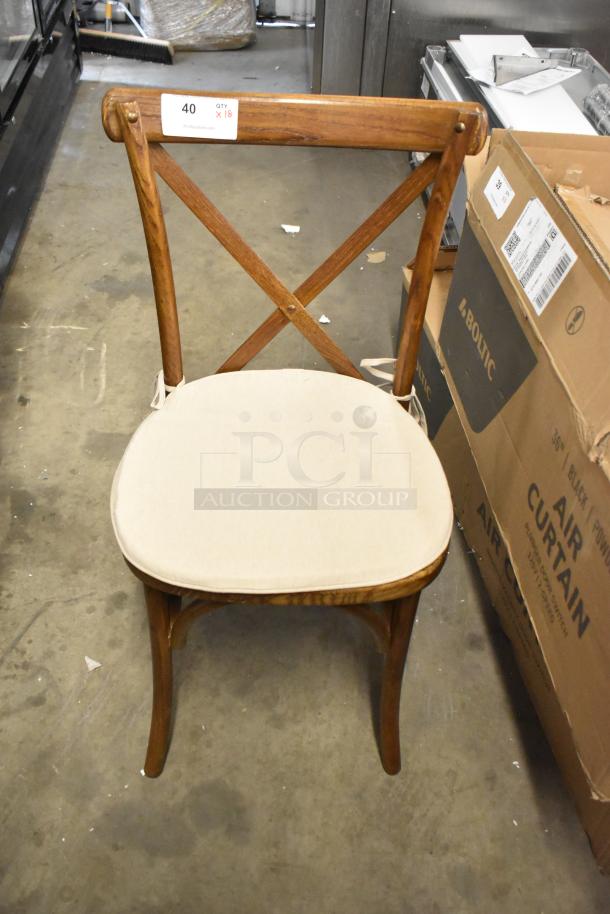 Brand new wooden dining chair with cross back, tan seat cushion. Scratch and dent condition. Quantity label: 18 available.