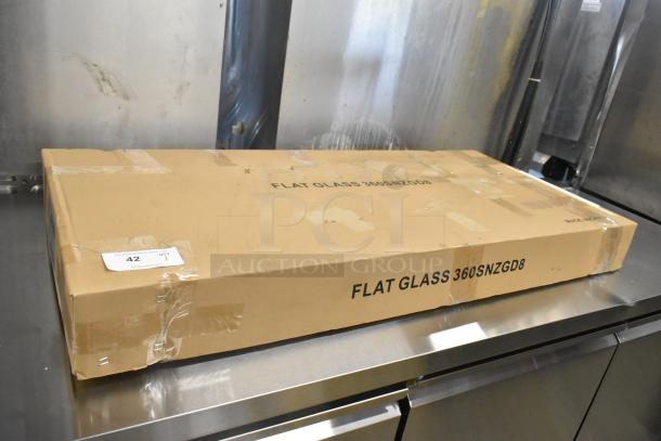 Brand new Avantco SNZGD8 49" flat glass sneeze guard, in original packaging marked "SCRATCH AND DENT," on stainless surface.