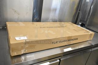 Brand new Avantco SNZGD8 49" flat glass sneeze guard, in original packaging marked "SCRATCH AND DENT," on stainless surface.