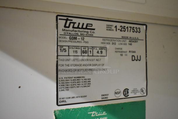 True GDM-12 cooler label indicating 115 volts, 1 phase, and NSF listing. Used for storing and displaying packaged goods.