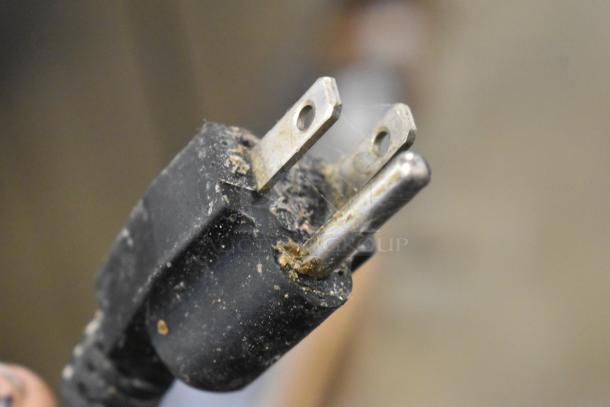 Close-up of a worn, three-prong electrical plug for the General GEM120 dough mixer. Dust and some residue visible.
