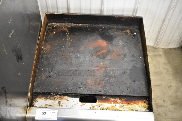 Cooking Performance Group stainless steel commercial gas griddle, used, with visible wear and food residue on flat surface.